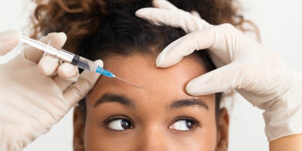 woman receiving Botox injection in forehead for wrinkle reduction and smooth skin at Howganics Med Spa