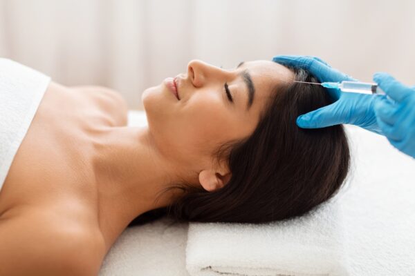 Cosmetologist does prp therapy against hair loss for indian woman