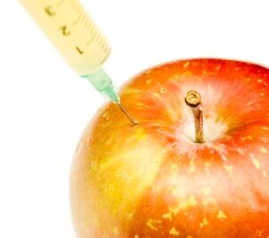Syringe extracting nutrients from an apple, symbolizing the natural energy and health benefits of Howganics B12 Shot
