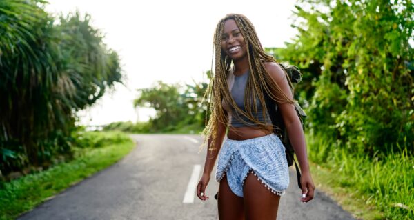Happy black woman walking on path
